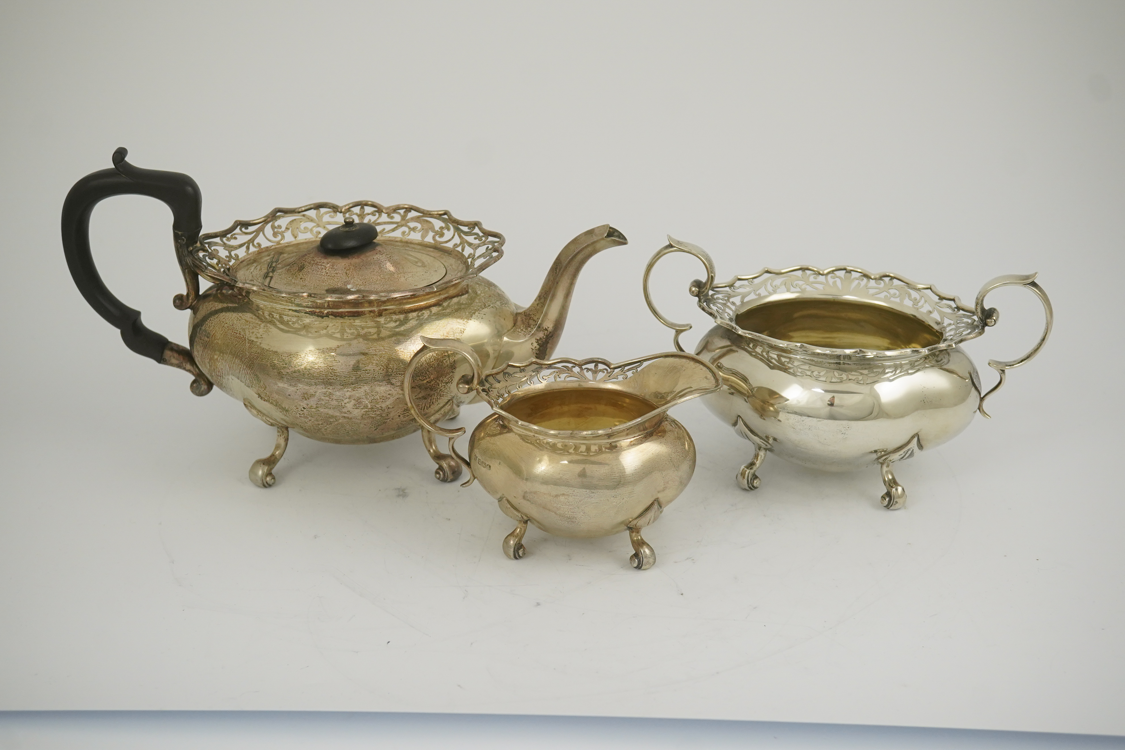 A George V three piece silver circular tea set by James Deakin & Sons